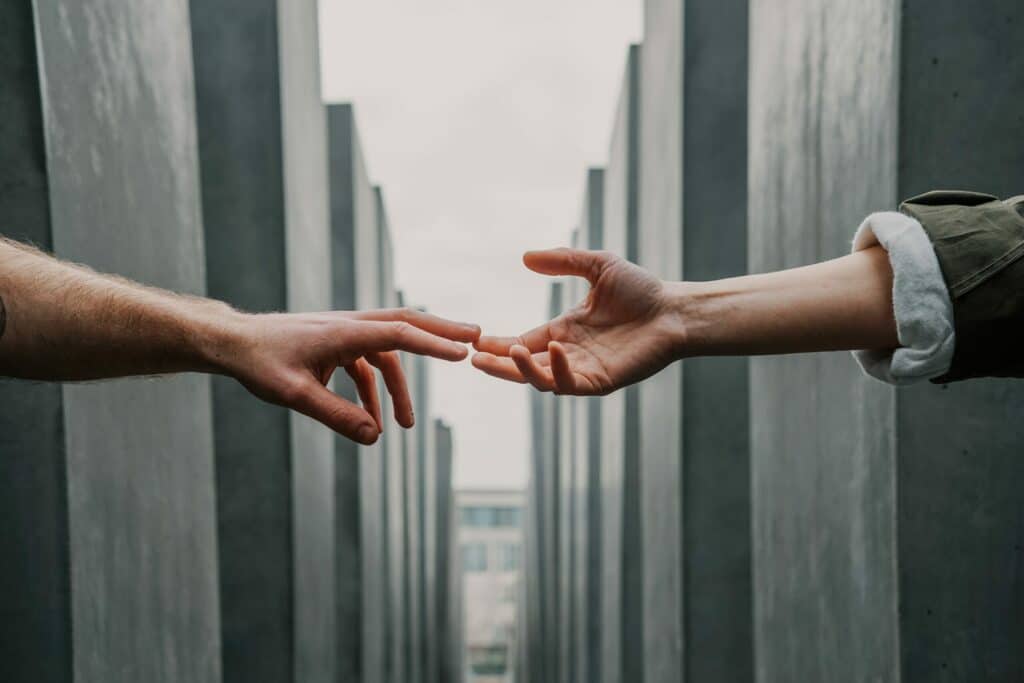 two hands reaching each other like we help our customer whit their PCI DSS assesment